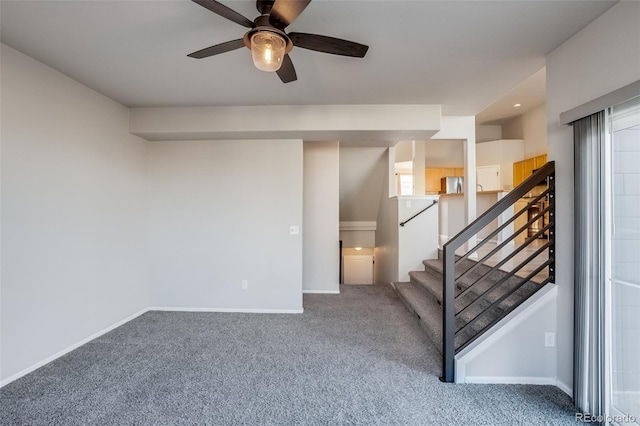 staircase featuring ceiling fan, baseboards, and carpet