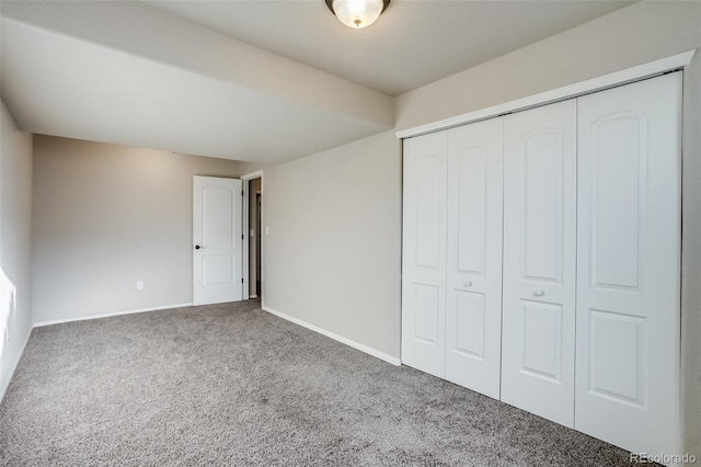 unfurnished bedroom featuring a closet, carpet floors, and baseboards