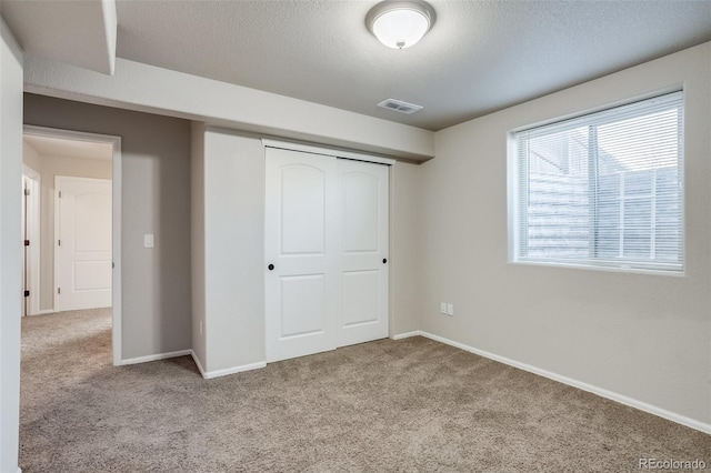 unfurnished bedroom featuring a closet, baseboards, visible vents, and carpet floors