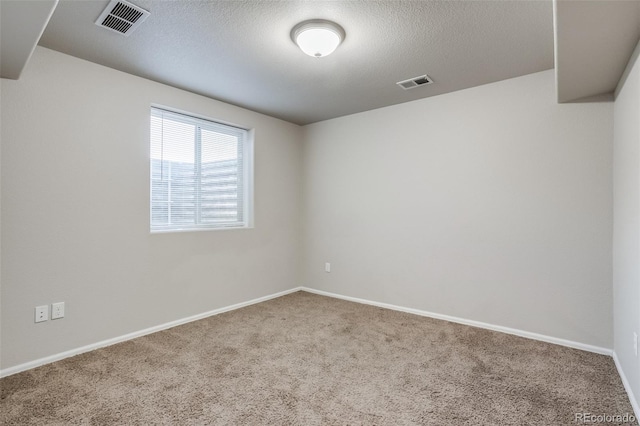 spare room with visible vents, baseboards, a textured ceiling, and carpet flooring