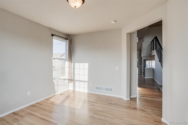 spare room with visible vents, light wood-style floors, and baseboards