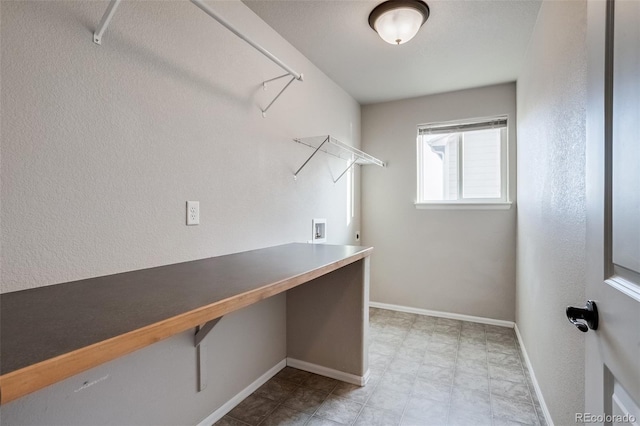 walk in closet with light floors and built in study area