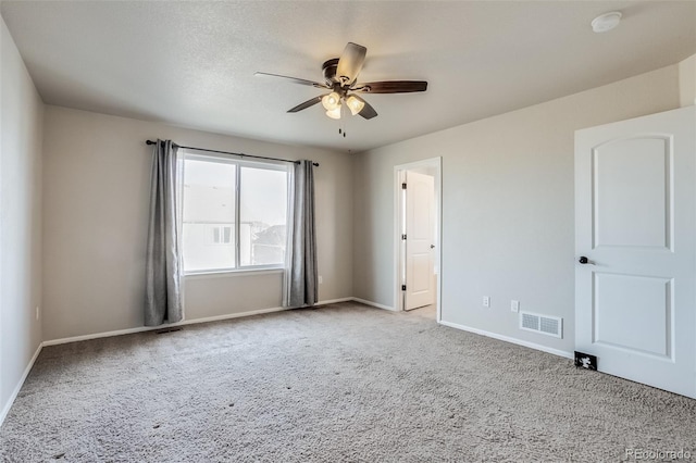 spare room with visible vents, baseboards, carpet floors, a textured ceiling, and a ceiling fan