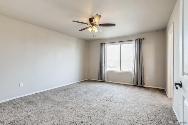 carpeted spare room with baseboards and ceiling fan