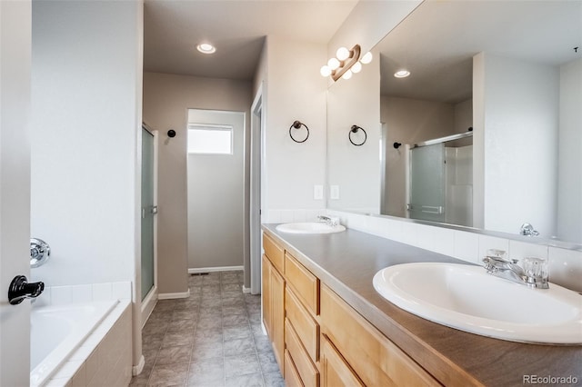 full bath featuring a sink, a garden tub, a stall shower, and double vanity