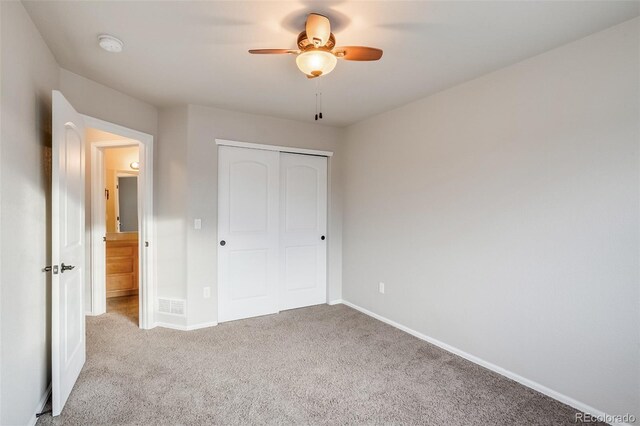 unfurnished bedroom with visible vents, baseboards, carpet floors, a closet, and a ceiling fan