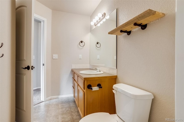 half bath featuring baseboards, toilet, and vanity