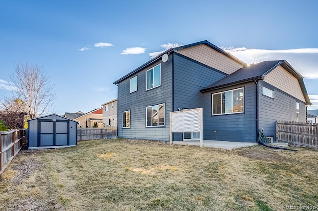 back of house with a storage shed, a fenced backyard, and an outbuilding