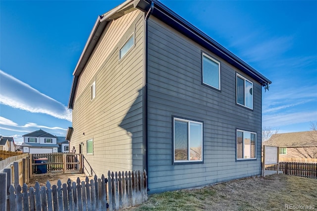 rear view of house with a fenced backyard