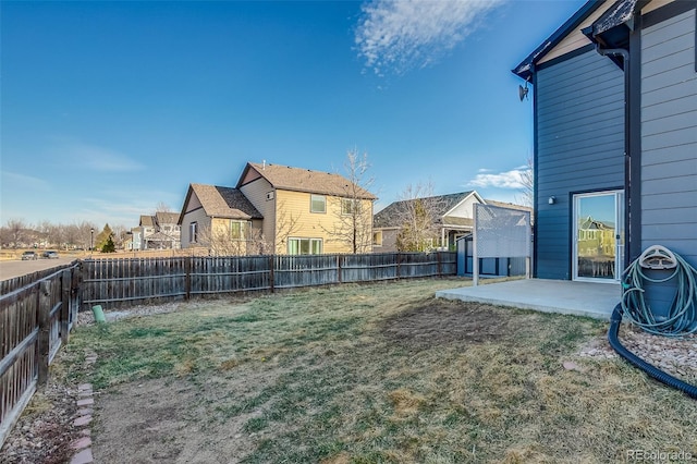 view of yard with a patio, a fenced backyard, and a residential view