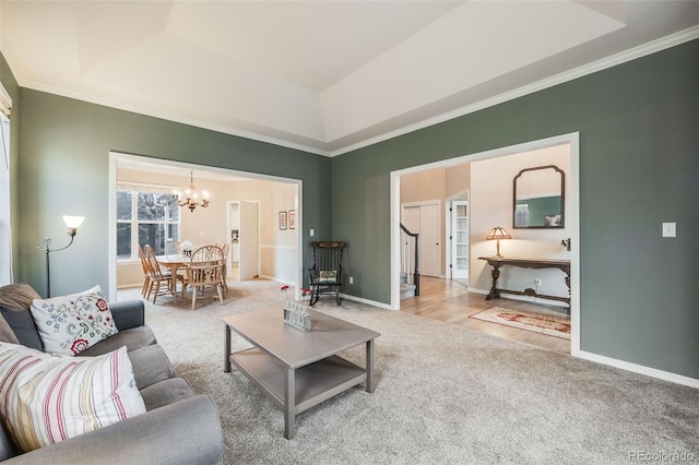 carpeted living room featuring a notable chandelier, a tray ceiling, and ornamental molding