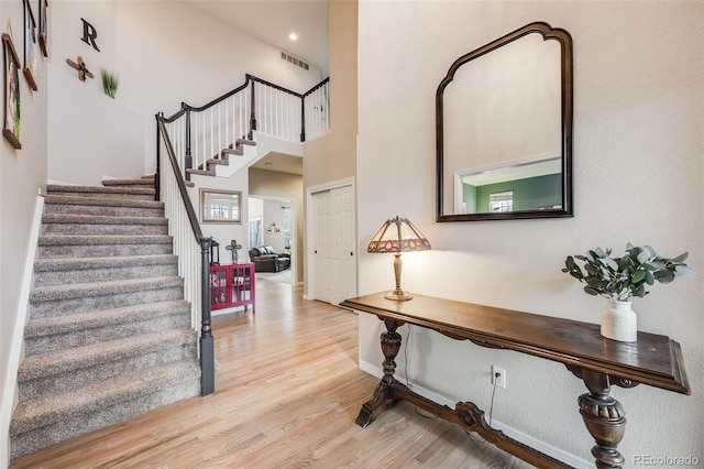 entrance foyer with a towering ceiling and light wood-type flooring