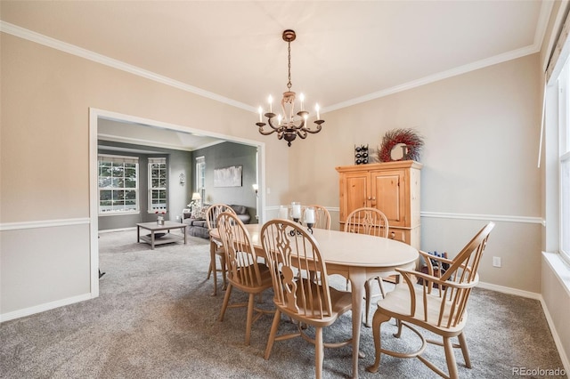 carpeted dining room featuring a notable chandelier and crown molding