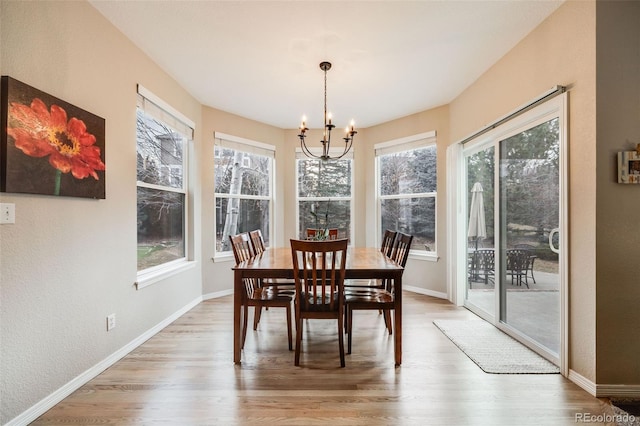 dining space featuring an inviting chandelier, a wealth of natural light, and light wood-type flooring