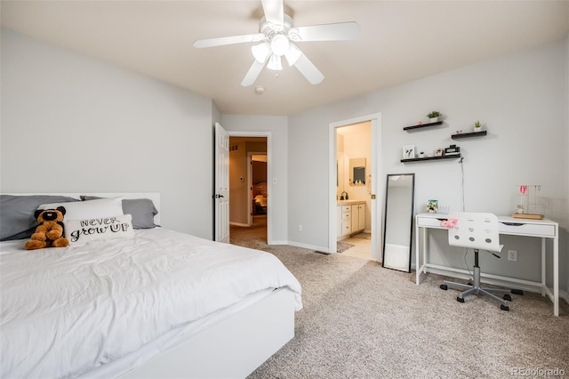 bedroom featuring ceiling fan, light colored carpet, and connected bathroom