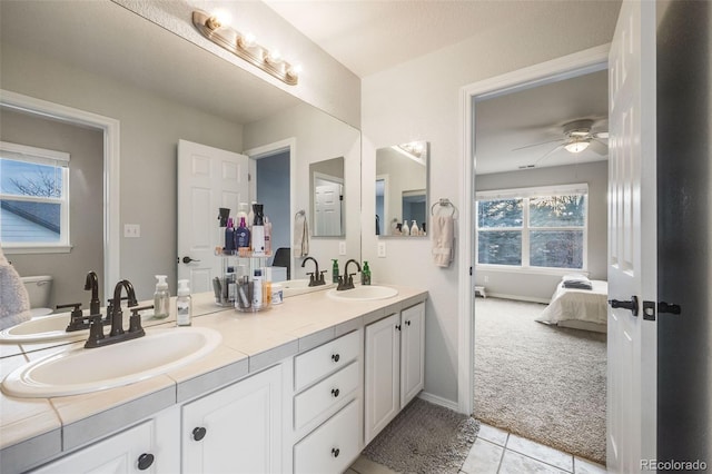 bathroom with ceiling fan, vanity, toilet, and tile patterned floors