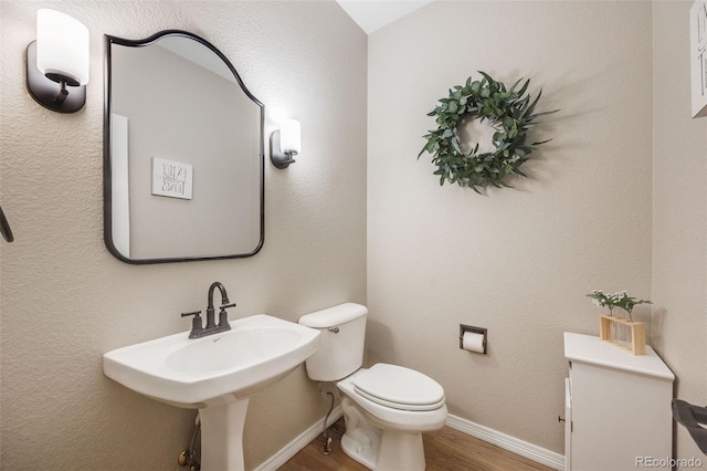 bathroom with hardwood / wood-style floors and toilet