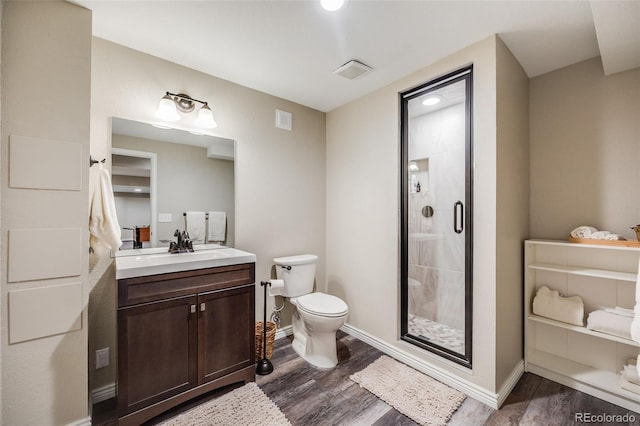 bathroom featuring hardwood / wood-style flooring, vanity, an enclosed shower, and toilet