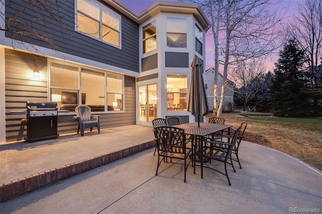 patio terrace at dusk featuring grilling area