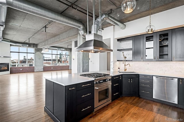 kitchen with island exhaust hood, dark hardwood / wood-style flooring, stainless steel appliances, sink, and pendant lighting