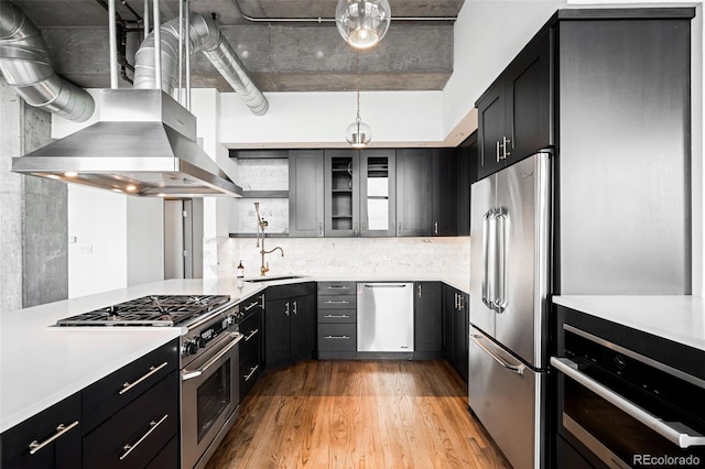 kitchen with light hardwood / wood-style flooring, hanging light fixtures, extractor fan, and high end appliances