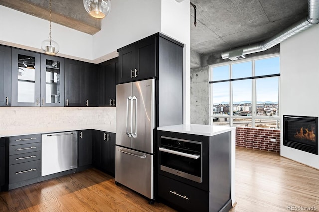 kitchen with wood-type flooring, stainless steel appliances, and hanging light fixtures