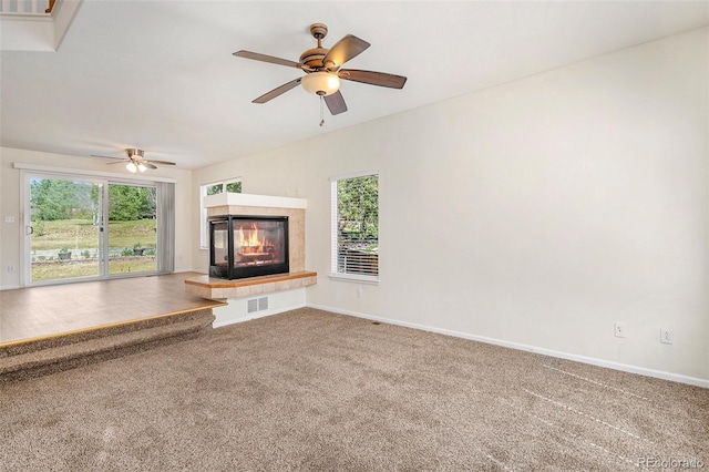 unfurnished living room with baseboards, visible vents, carpet flooring, and a tile fireplace