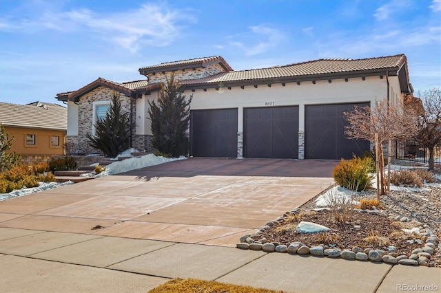 mediterranean / spanish house featuring driveway, a tile roof, a garage, and stucco siding