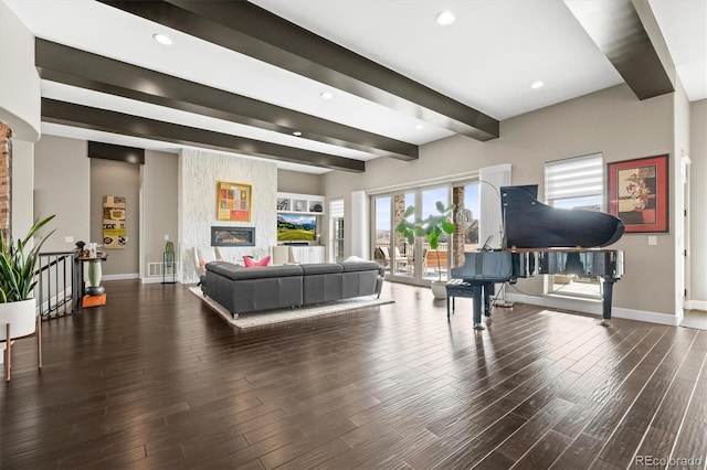 living area featuring beam ceiling, a large fireplace, baseboards, and wood finished floors