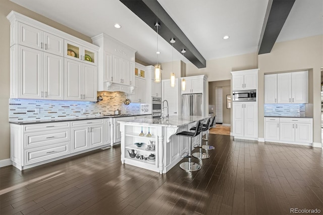 kitchen with open shelves, stainless steel appliances, a kitchen island with sink, and white cabinetry