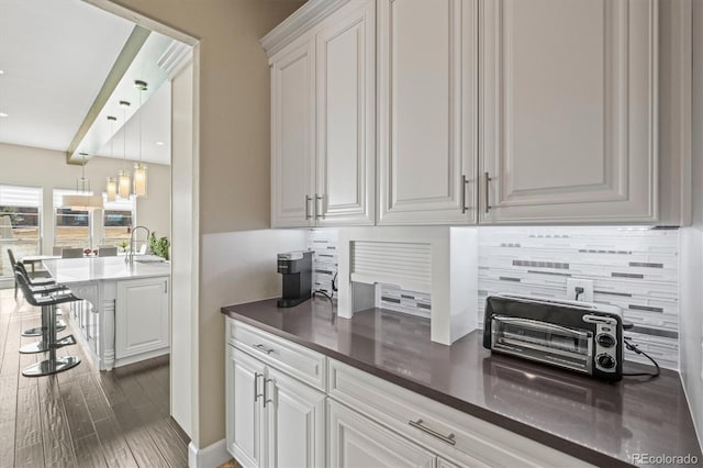 kitchen featuring dark countertops, backsplash, and white cabinetry