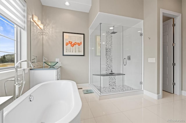 full bath with a stall shower, a soaking tub, tile patterned flooring, and baseboards