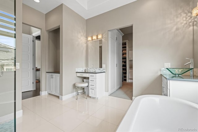 full bathroom with baseboards, a freestanding tub, vanity, and tile patterned floors