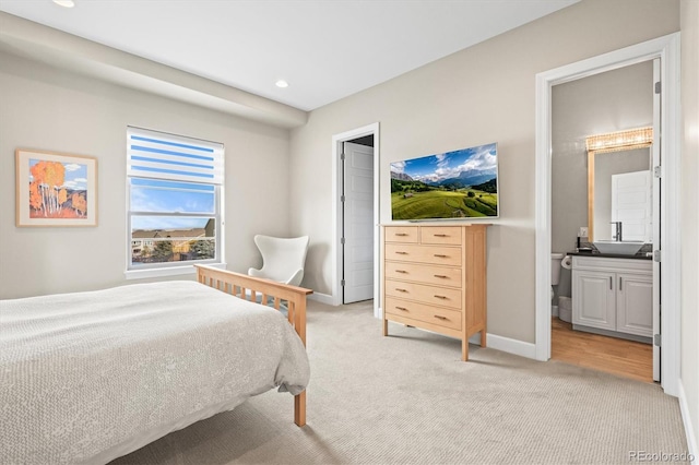 bedroom featuring light carpet, ensuite bath, baseboards, and recessed lighting