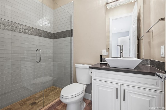 full bathroom with a stall shower, vanity, and toilet