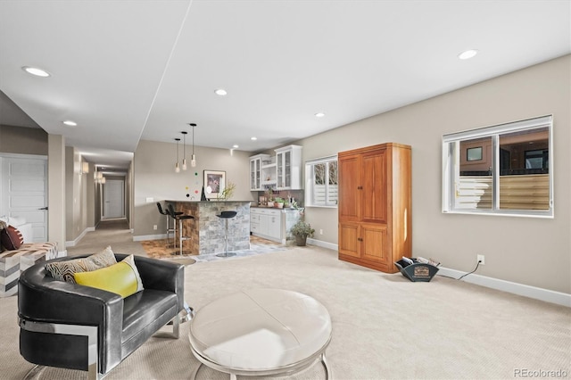 living area featuring recessed lighting, baseboards, and a dry bar