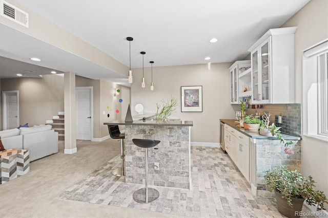 kitchen with open floor plan, dark countertops, glass insert cabinets, and white cabinets