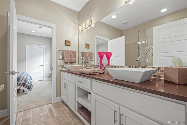 bathroom with recessed lighting, double vanity, a sink, and ensuite bathroom