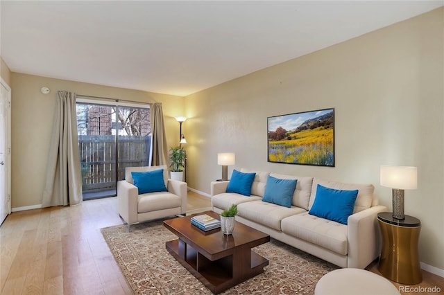 living area featuring light wood-style floors and baseboards