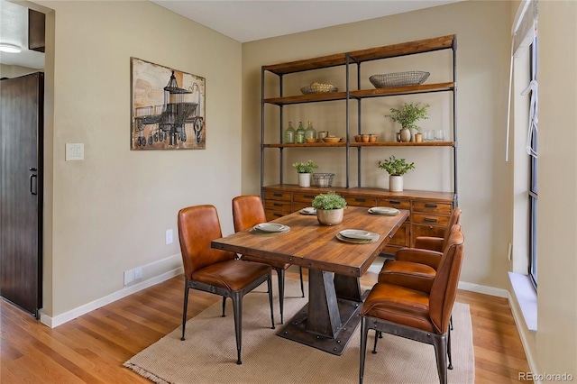 dining area with light wood-style floors and baseboards