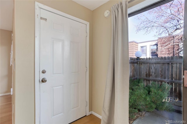 doorway featuring wood finished floors and baseboards