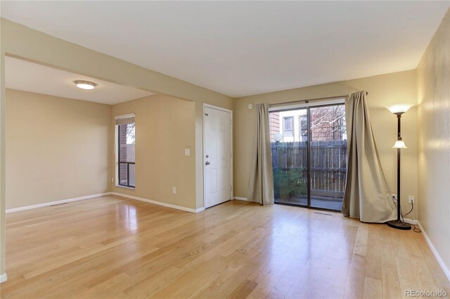 empty room featuring baseboards and light wood-style floors