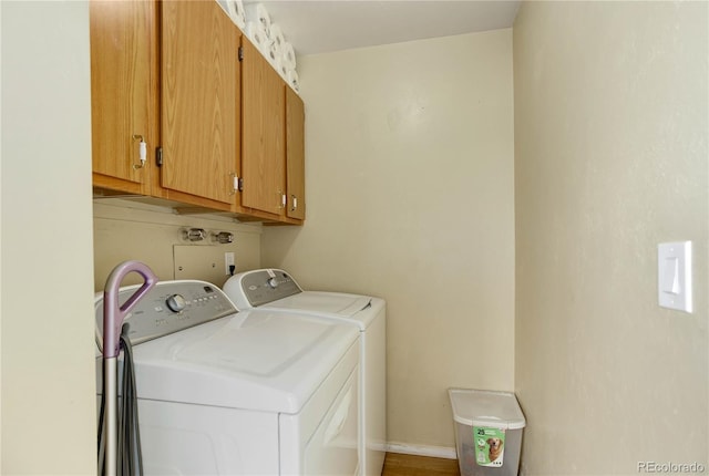 laundry room with cabinet space, washing machine and dryer, and baseboards