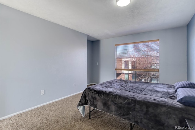 carpeted bedroom with baseboards and a textured ceiling