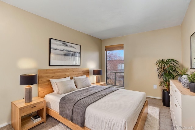 bedroom with light colored carpet and baseboards