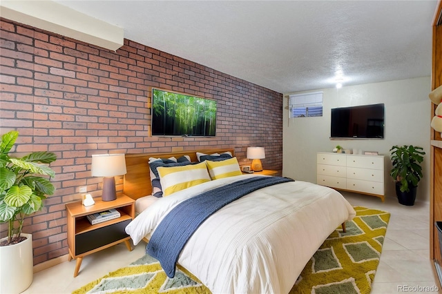 bedroom featuring brick wall and a textured ceiling