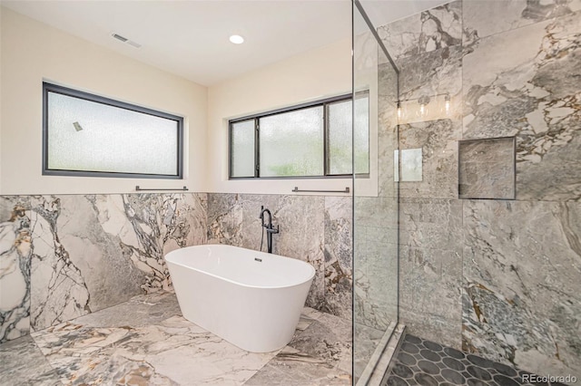 bathroom featuring tile walls and separate shower and tub