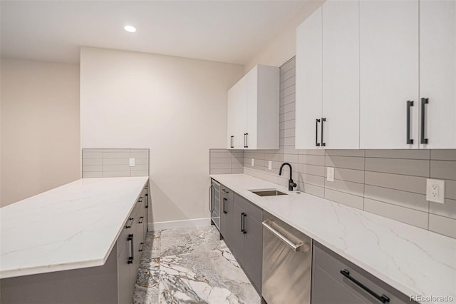 kitchen with white cabinetry, sink, light stone counters, tasteful backsplash, and gray cabinetry