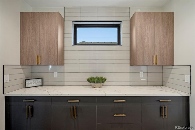 kitchen featuring backsplash and light stone countertops