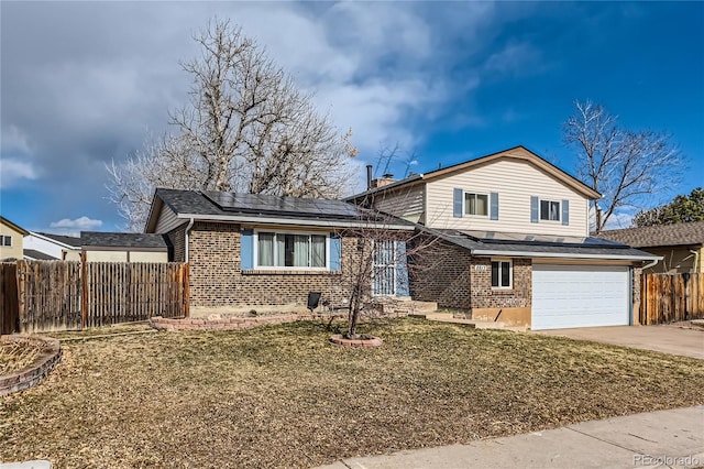 view of front of home featuring concrete driveway, brick siding, fence, and solar panels